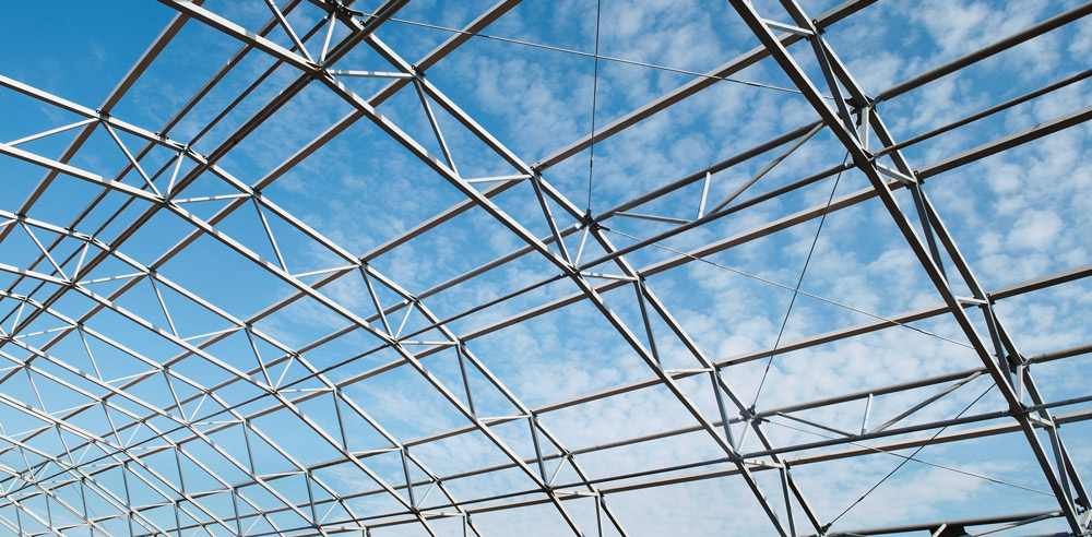 Flexibilität durch fortgeschrittene Verbindungstechnik Gebogenes Stahlgerüst vor blauem Himmel